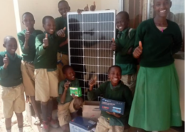 A group of children smile while presenting Ndinyika Primary School’s new solar system panel